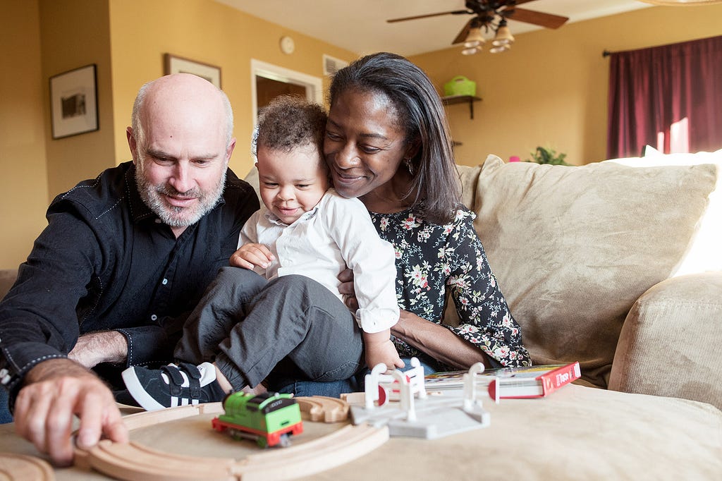 mother and father hold their toddler son