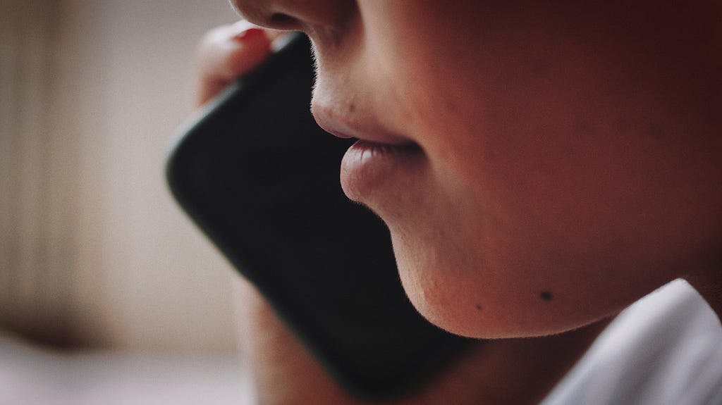 Woman speaking on phone — closeup of mouth