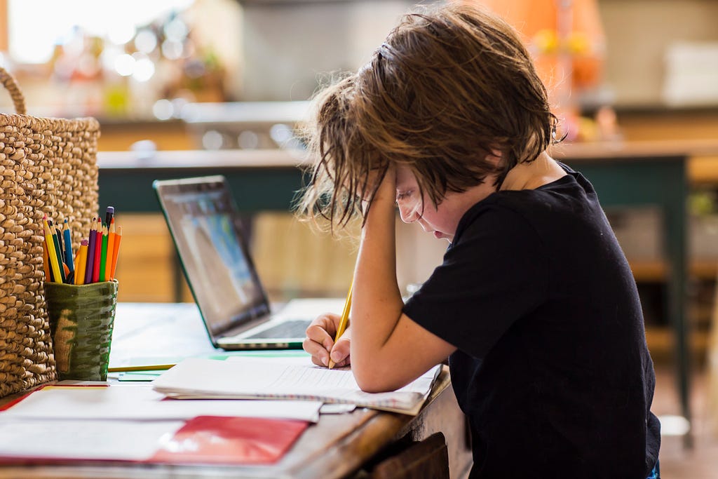 Un alumno de primaria realiza las tareas en casa siguiendo las clases a distancia por ordenador.