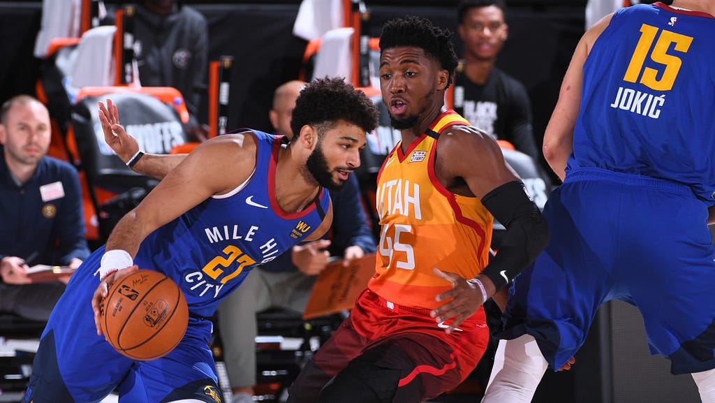 Two basketball players (Jamal Murray (left) and Donovan Mitchell (right)) facing off