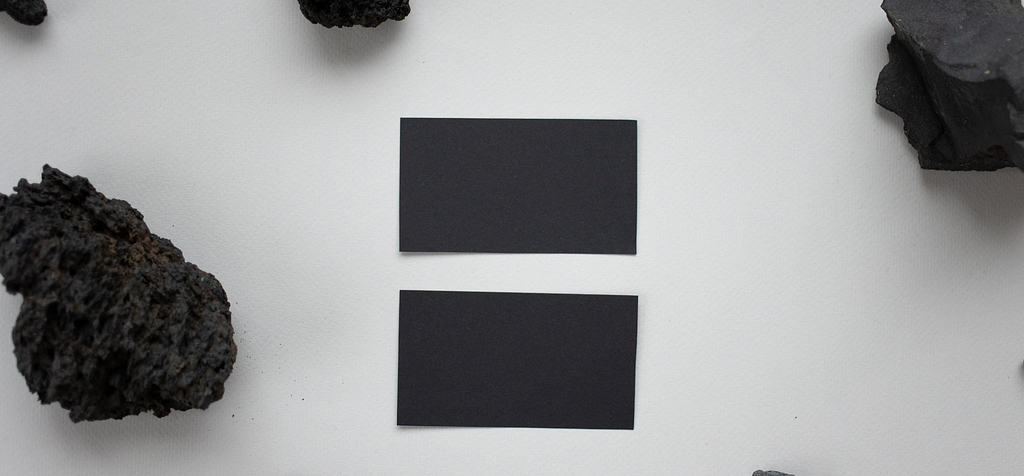 Black rocks and black rectangles on porous white paper