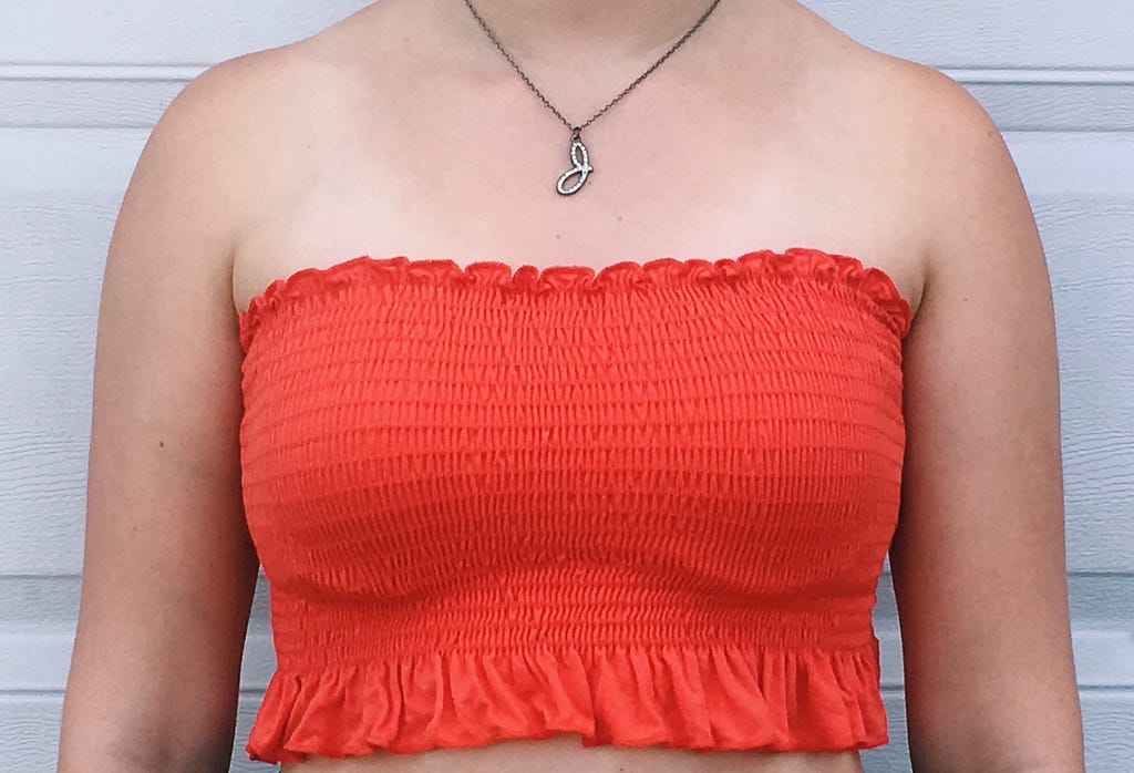 An orange, ruffle trim tube top.