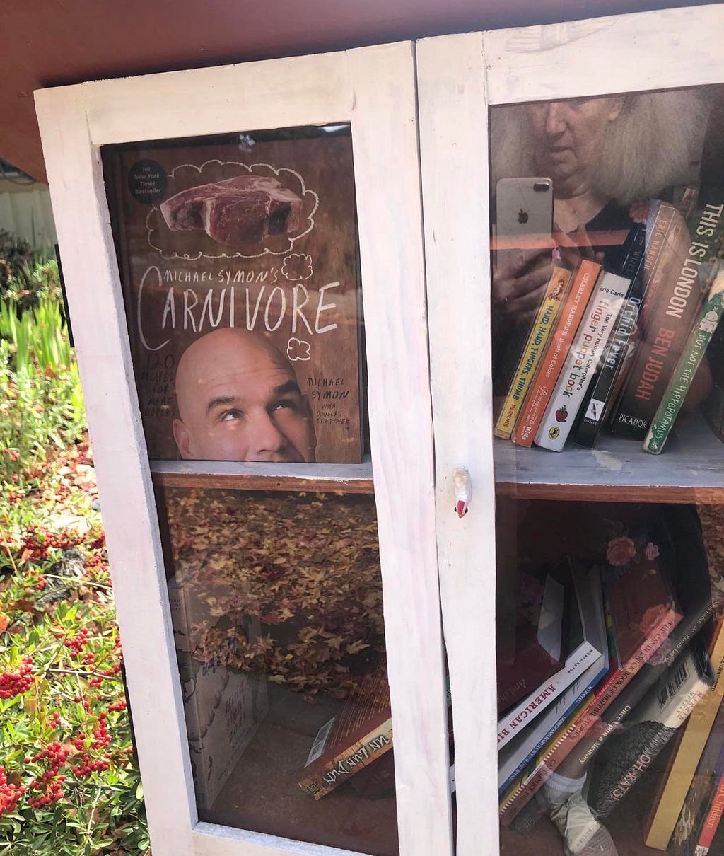 Book cover in little library showing man with word Carnivore