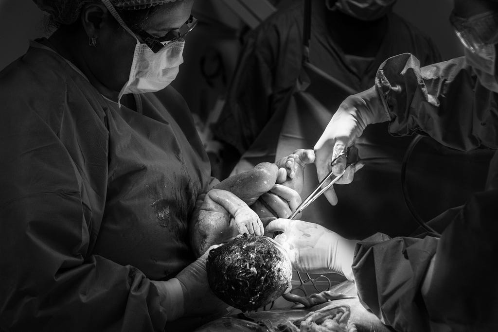 Photo of surgeons with baby by Jozemara Friorili Lemes