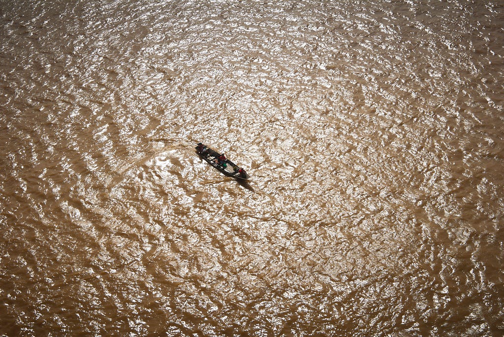 Indigenous Traders Crossing the Amazon River