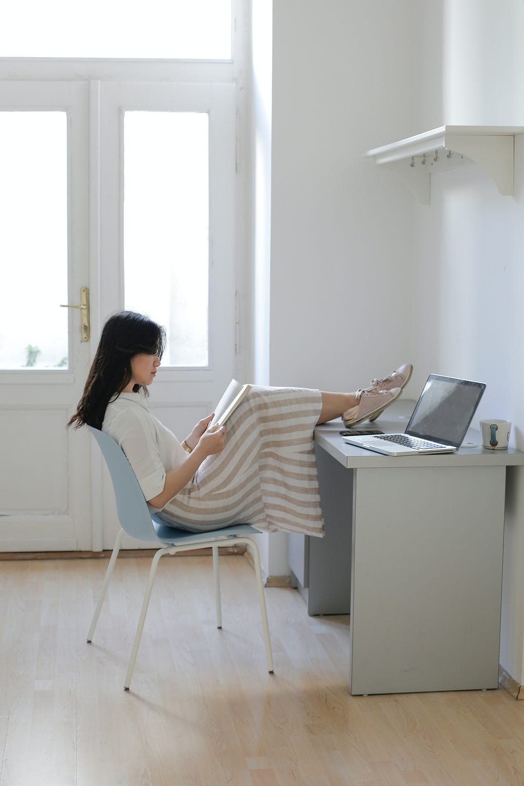 Girl reading book while sitting at her desk