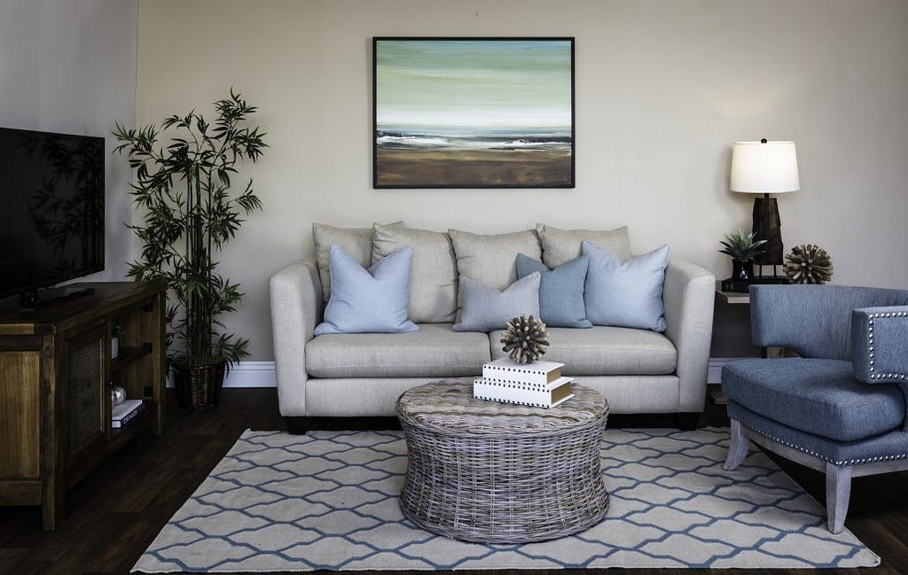 Beach themed living room with neutral sofa and wicker coffee table