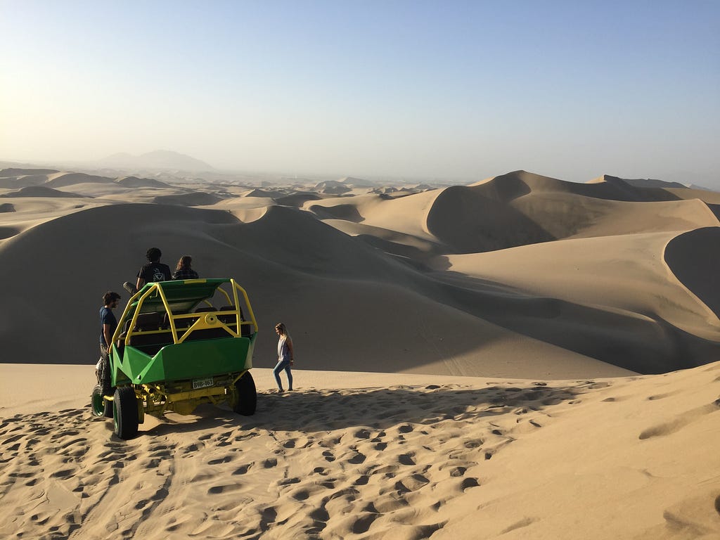 A car buggy sitting on top of the sand dunes in Huacachina Peru during a sand boarding tour