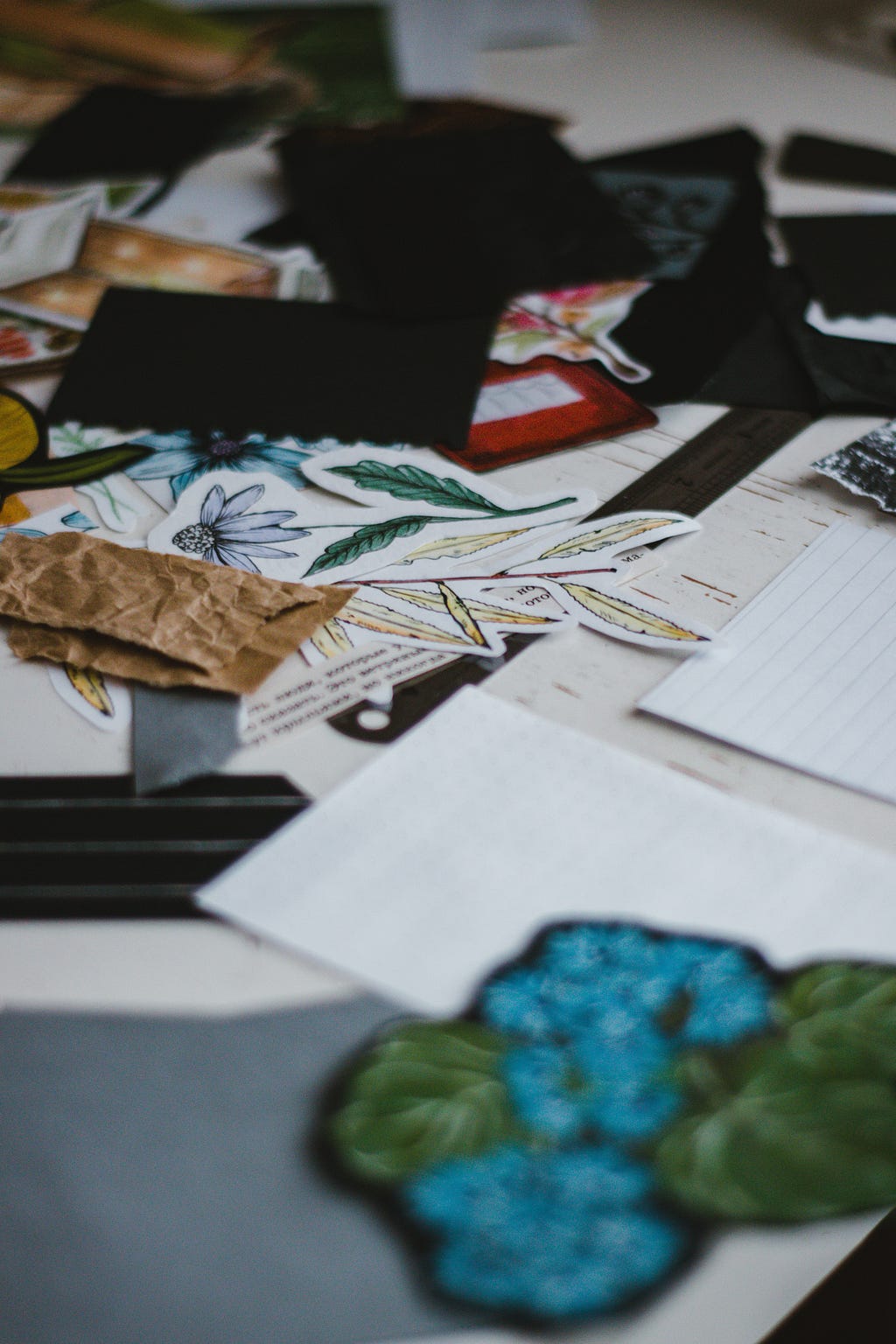 Mix of paper cuttings, text cuttings, pages and books laid out in an unorganised manner