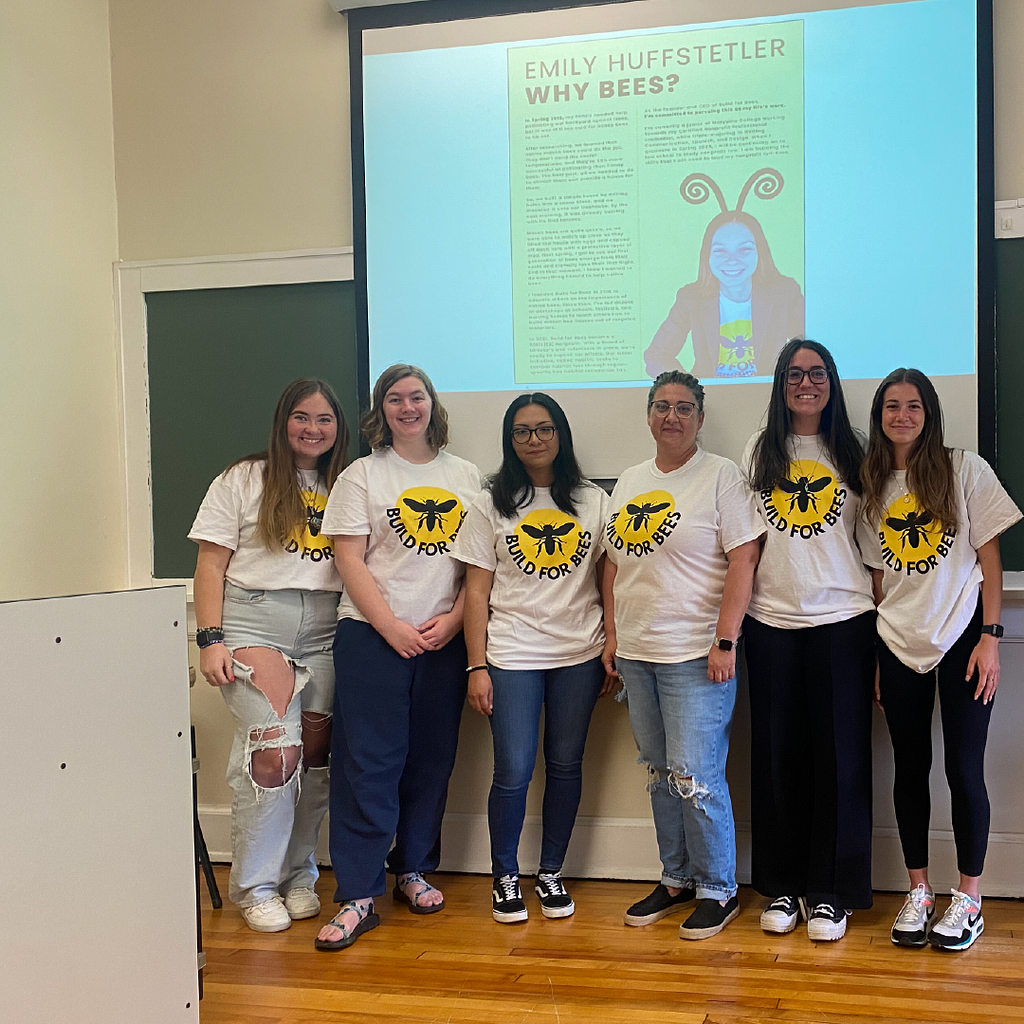 Group of Maryville College students standing in a classroom wearing matching Build for Bees t-shirts.
