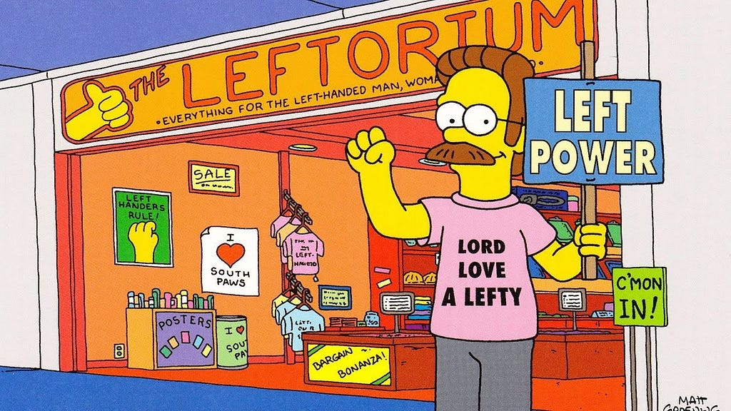 Una imagen de Ned Flanders posando frente su tienda de insumos para zurdos. Ned lleva puesta parafernalia pro-zurdismo.