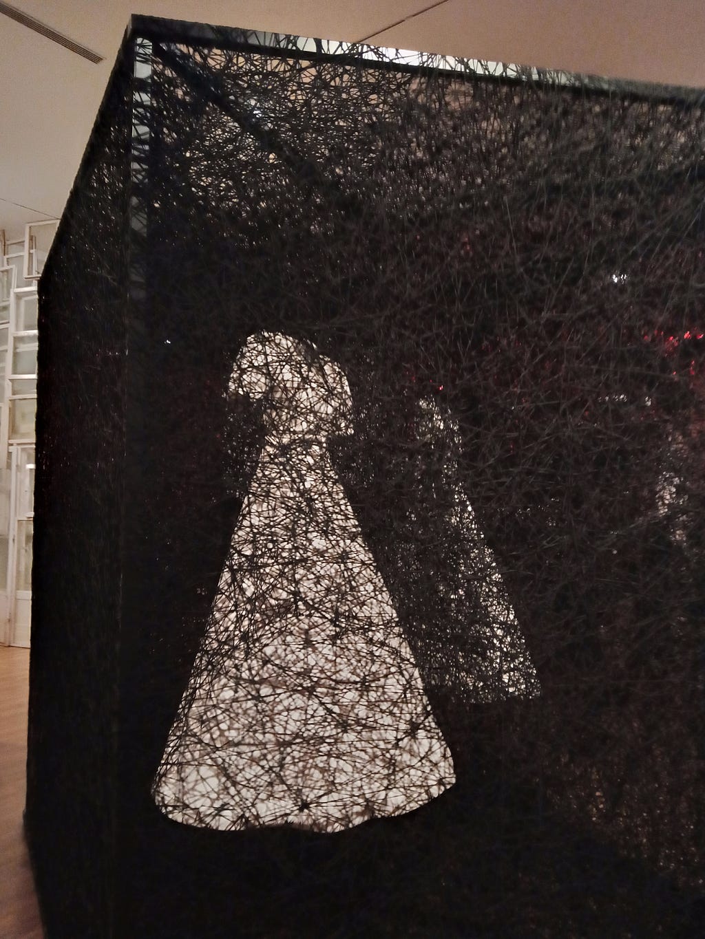 Two white dresses in one black cube (one of many installations from Chiharu Shiota’s exhibition: The Soul Trembles)