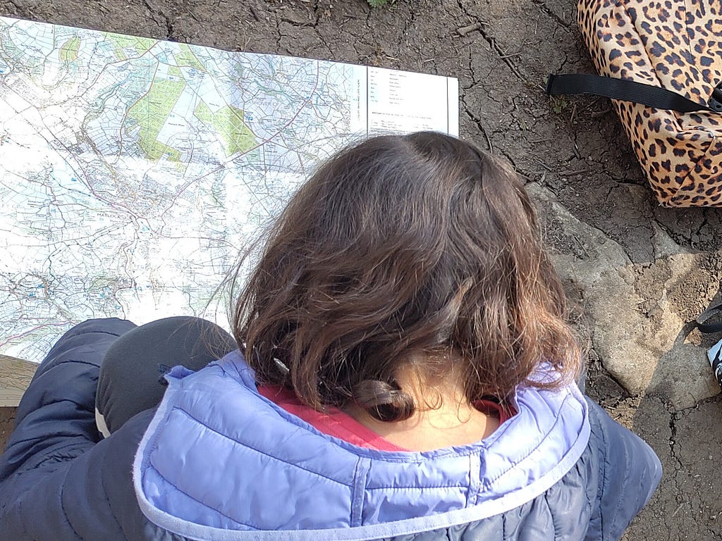 Young girl looking at Ordnance Survey map of the Peak District