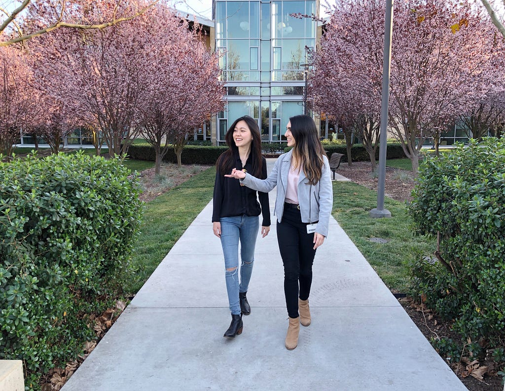 April being taken on a tour of the VMware campus by a designer on the team, with cherry blossom trees along a pathway