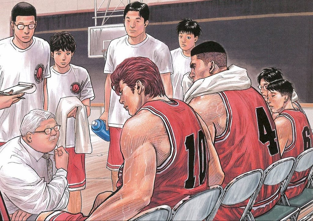 Immagine di tutta la squadra che ascolta l’allenatore Anzai