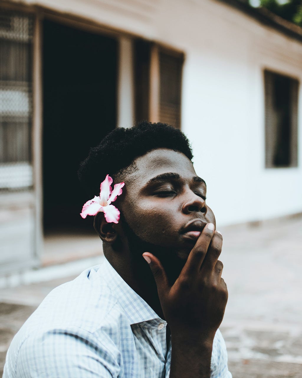 A beautiful Black man with a flower behind his ear.