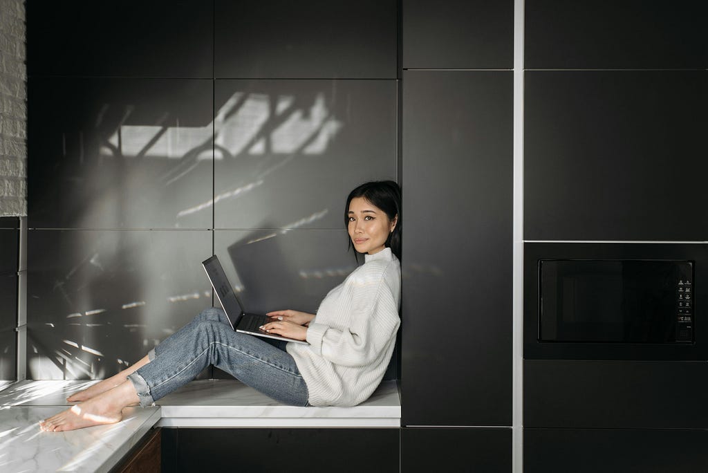 Woman working with her laptop and smiling at the camera