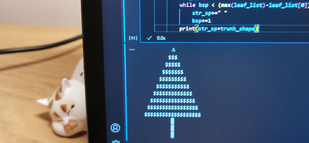 A Christmas Tree ASCII art created by an algorithm written in Python shown on a computer screen