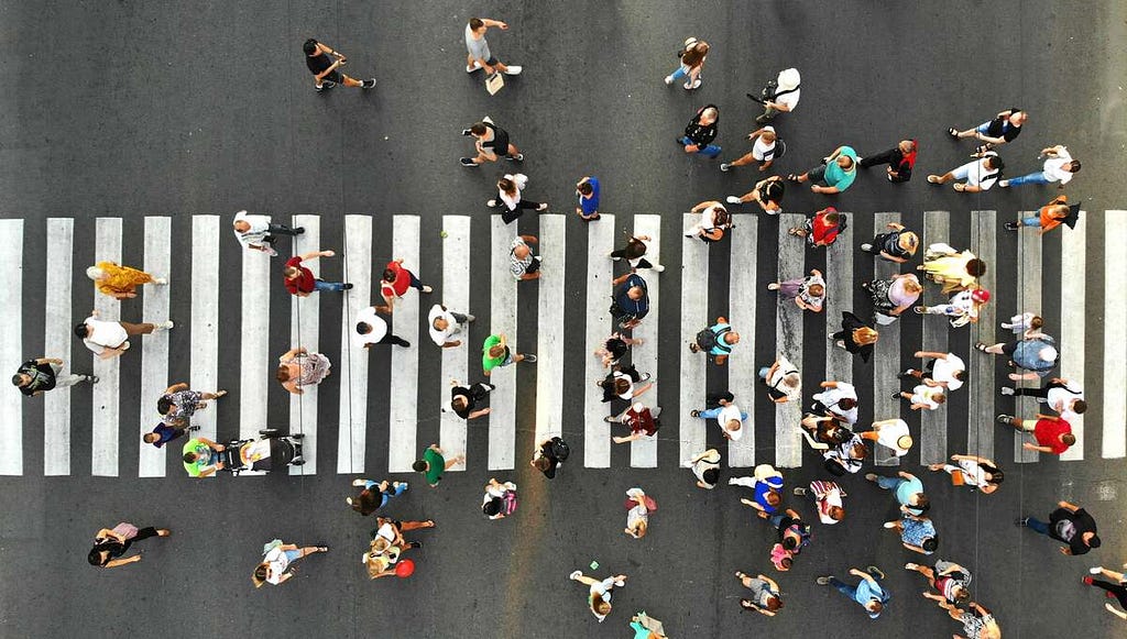 A top view photo shows many people going through the pedestrian crosswalk.