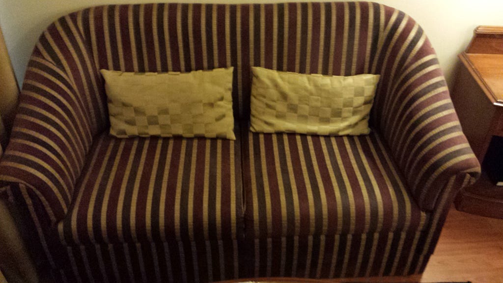 A brown and yellow schemed love seat in my hotel room