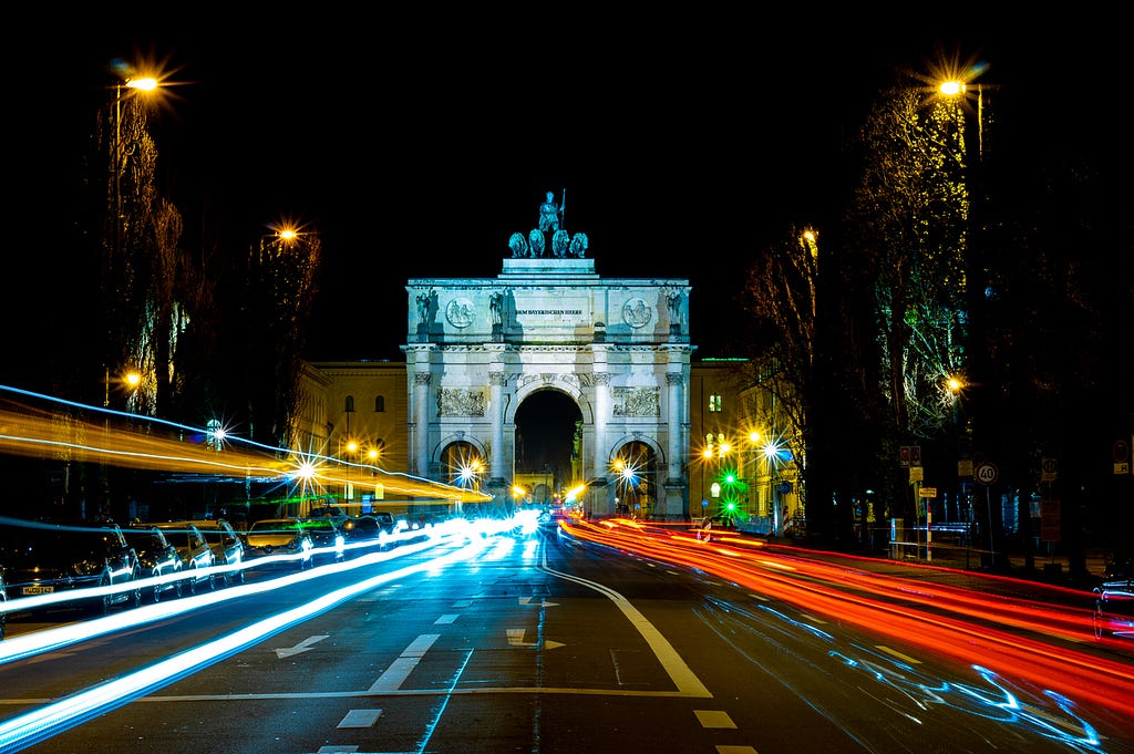 A long exposure night-time photo of Leopoldstrasse in Munich on which Allianz X is located.