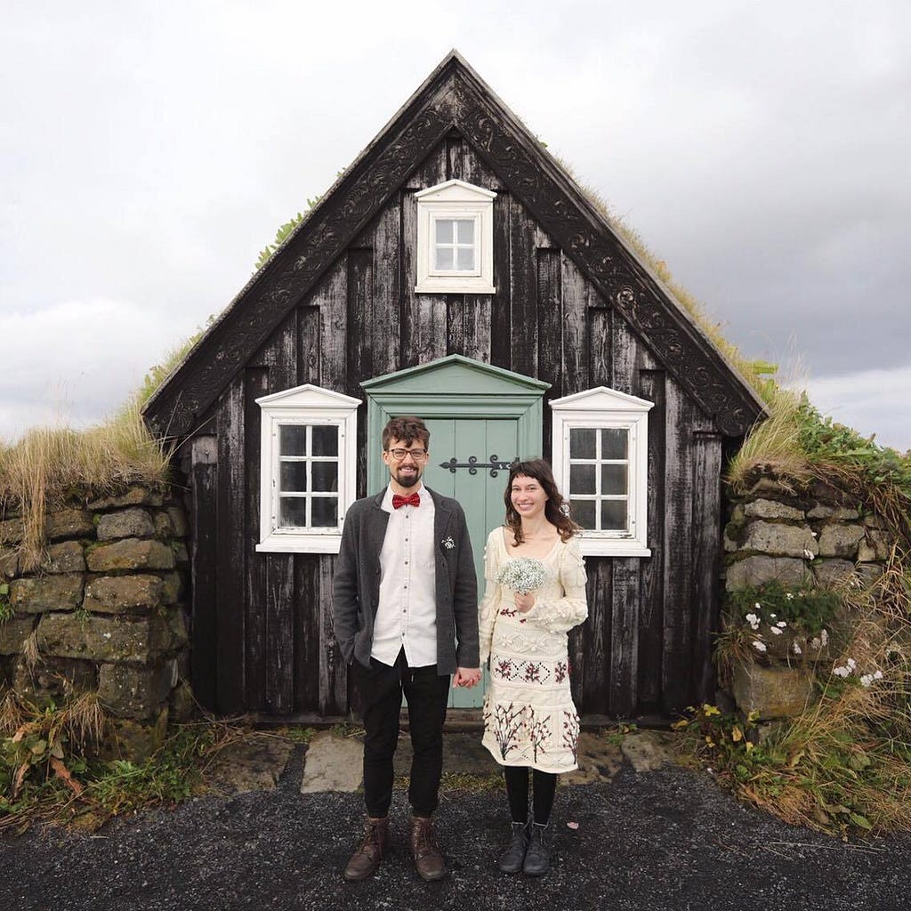 Photo of Josip and his wife Lorena standing outside a small house