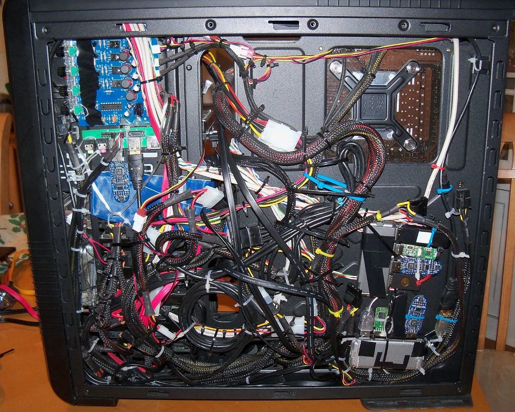 A desktop PC with exposed internals showing messy cables
