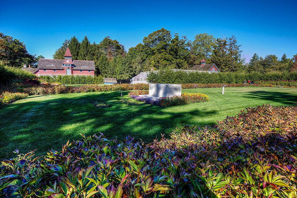 a manicured field with three gravestones in the center