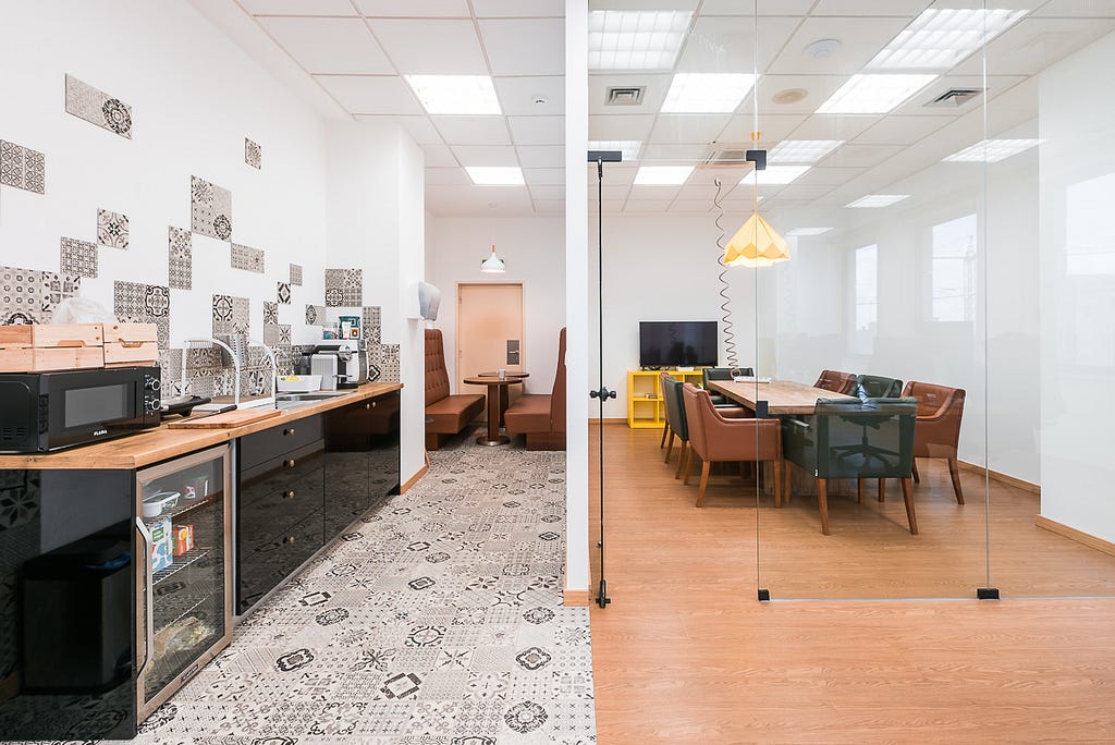 Image of an empty office space, looking at a meeting room and eating area