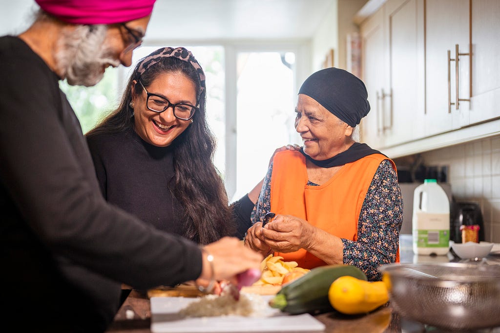 A family, including two older people, prepare a meal together