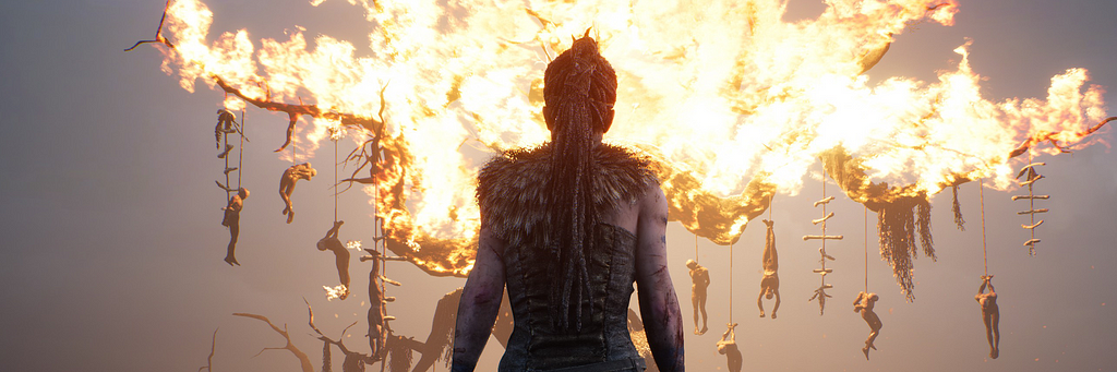 Senua, protagonista di Hellblade: Senua’s Sacrifice, davanti a un albero in fiamme.