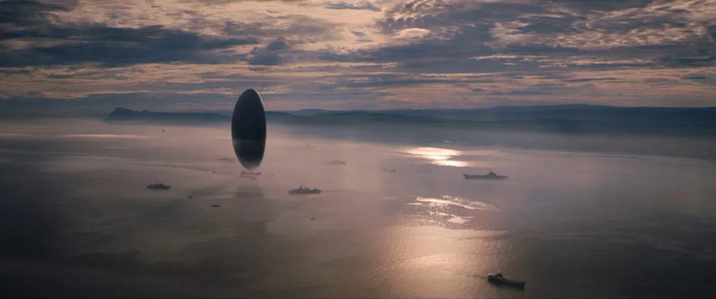 Une image du film ”Arrival”. Un vaisseau extra-errester en forme de tour semble flotter sur la mer.