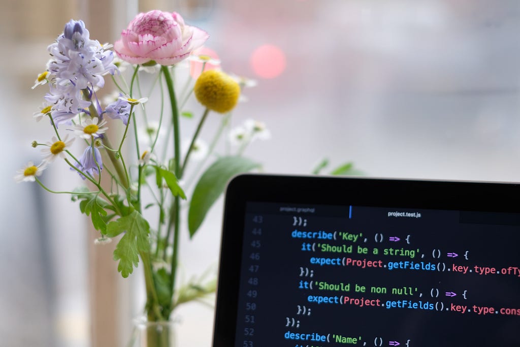 JavaScript on a computer screen with a bouquet in the background