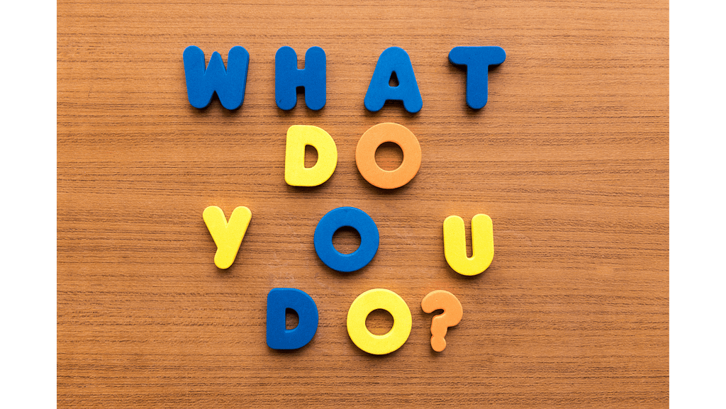 What do you do? lettering blocks on a brown background.