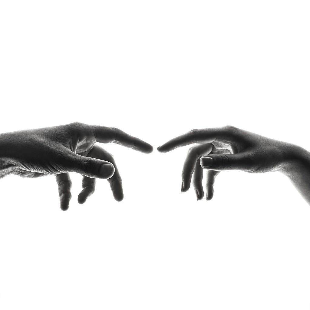 Two index fingers attempting to touch each other