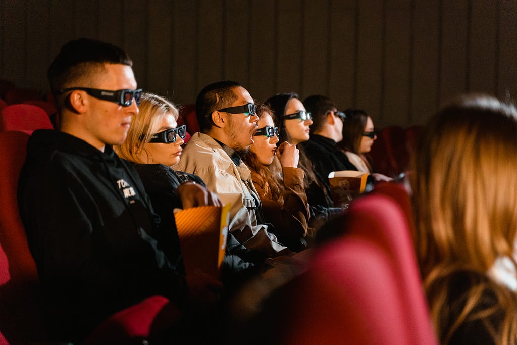 Movie theater audience that is awed and inspired by technology in the movies.