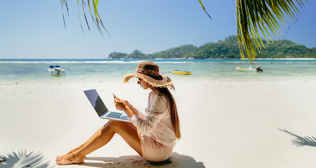 A woman freelancer on the beach. Photo by avanti_photo on Canva.