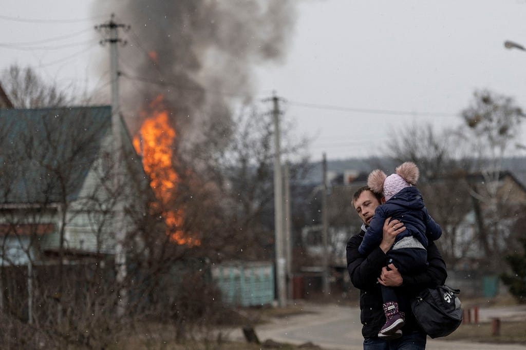 Residents flee from the town of Irpin, Ukraine, after heavy shelling by Russia destroyed the only escape route used by locals, March 6, 2022. Photo by Carlos Barria/Reuters