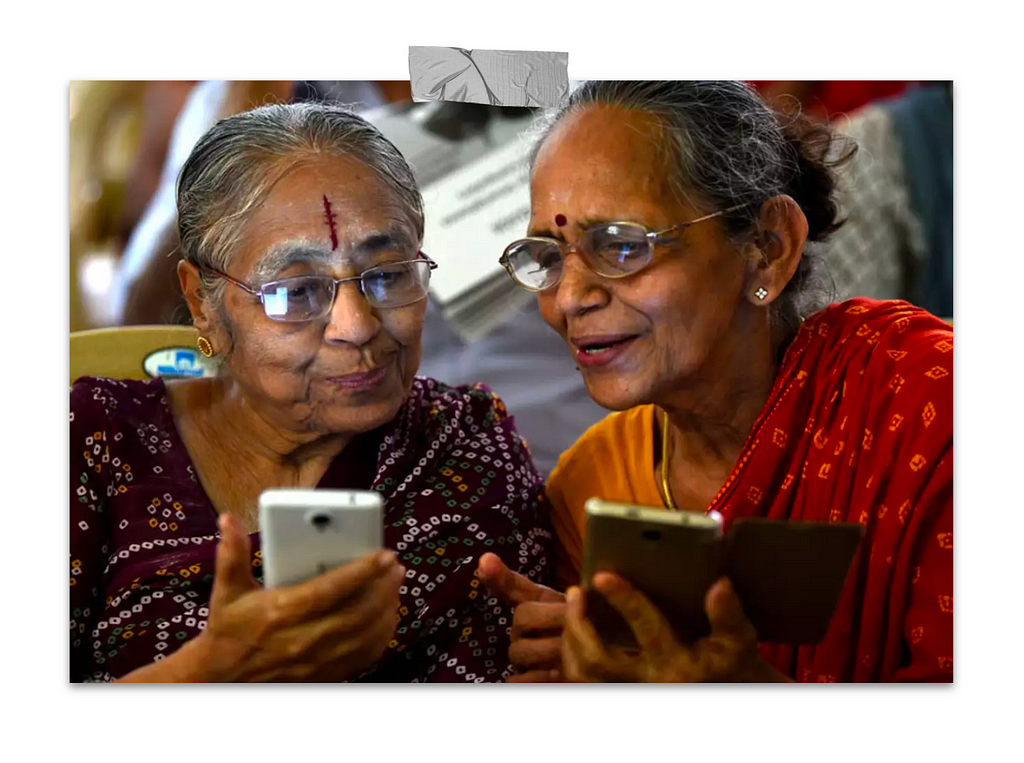 Image of two elderly women excitedly using mobile phones, showcasing the accessibility and power of technology at their fingertips.