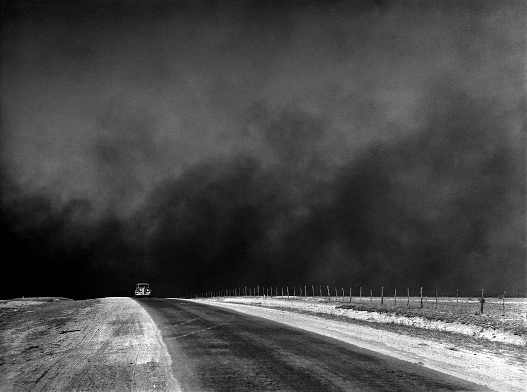 A car drives ahead of a massive dust storm, known as a “black blizzard,” in the Dust Bowl era.