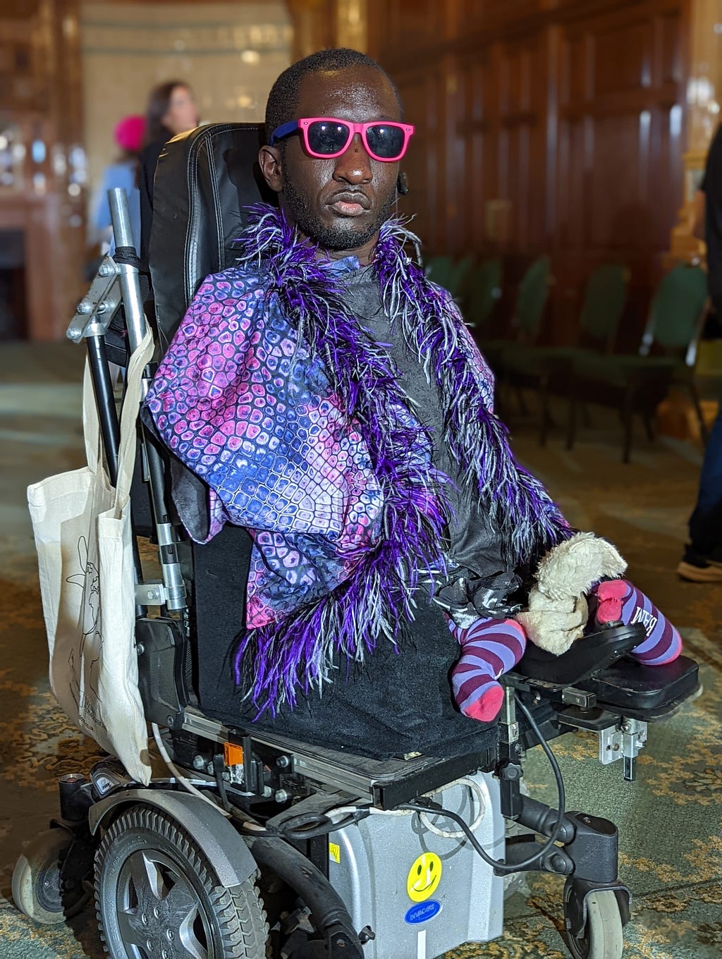 A Black man in a wheelchair looking stylish at London Fashion Week.