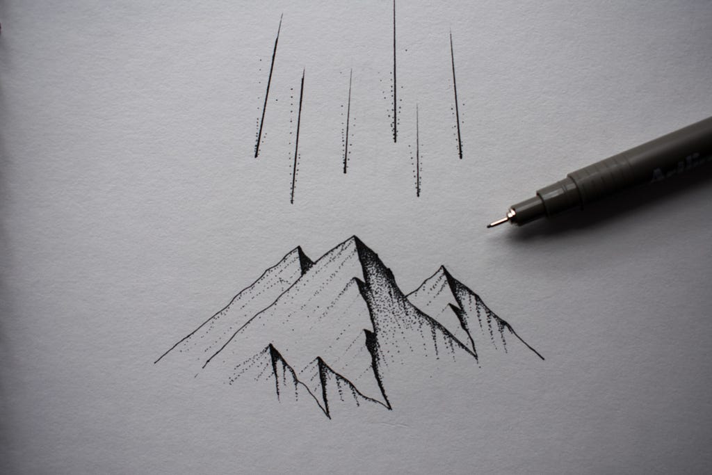A small illustration of a mountain range, with a fine-tip pen resting on top of the paper.