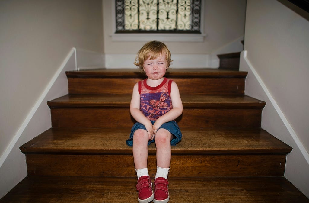 A little girl sitting on the stairs