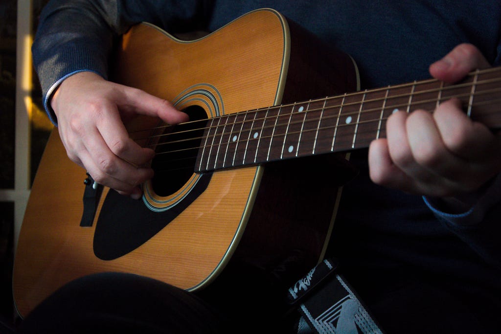 A guitarist playing an acoustic guitar.