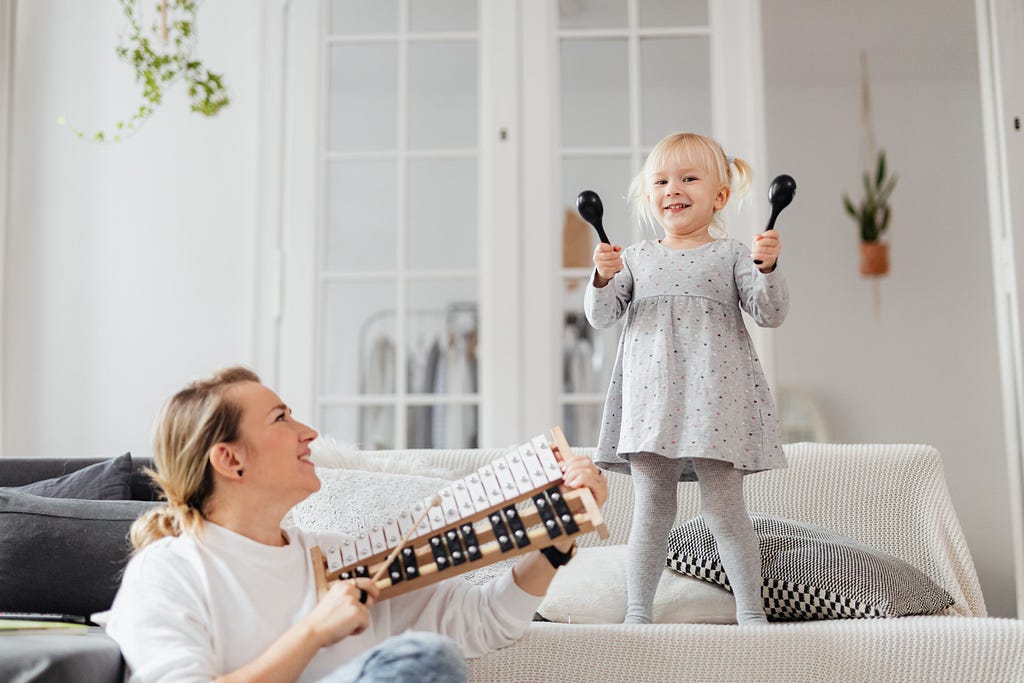 mother and young daughter playing instruments together
