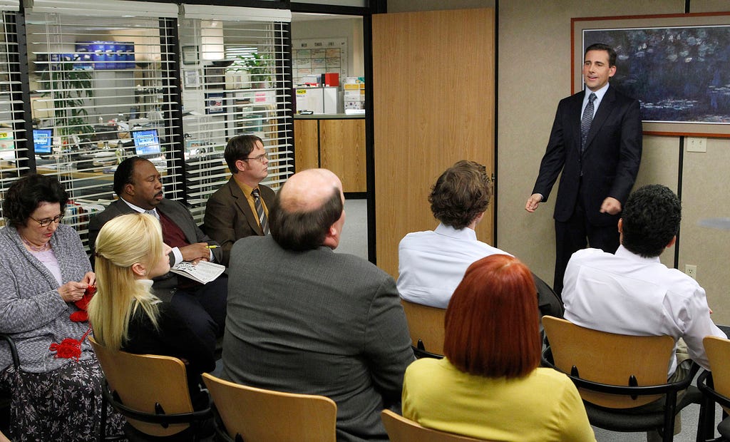 Scene from The Office with Michael Scott in a meeting.