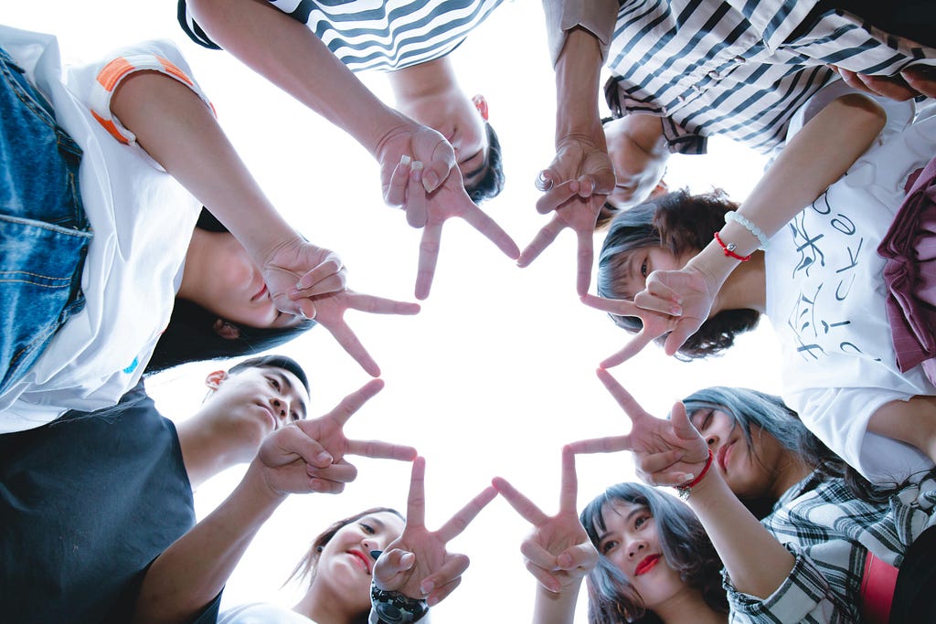 Group of people forming a star with their fingers