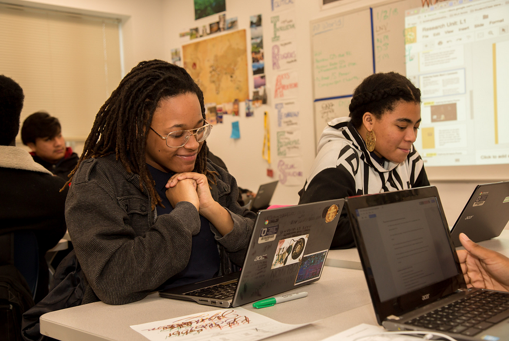 Two students on their laptops completing a CommonLit lesson.