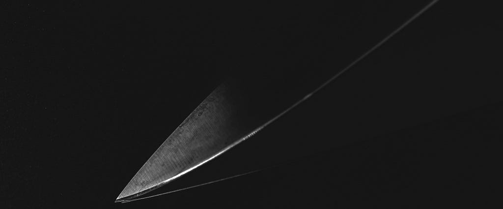 An angled sword tip on a dark background.