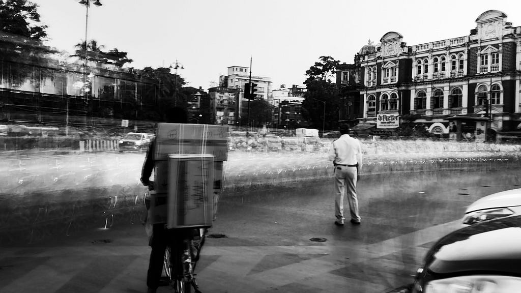 A traffic policeman and a vendor with boxes on his cycle in Mumbai’s fort area